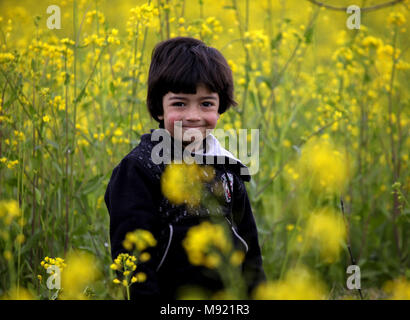 Srinagar, au Cachemire sous contrôle indien. Mar 21, 2018. Un enfant pose pour des photos dans un champ de fleurs de moutarde dans Panzan village à environ 25 km au sud-ouest de Srinagar, la capitale d'été du Cachemire sous contrôle indien, le 21 mars 2018. Credit : Javed Dar/Xinhua/Alamy Live News Banque D'Images