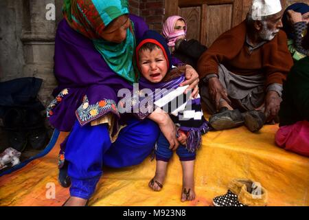 Srinagar, au Cachemire, en Inde. Mar 21, 2018. Un garçon Cachemirien pleure après un travailleur de santé traditionnel utilise les sangsues pour sucer le sang dans le cadre d'un traitement à Srinagar. Chaque année, les travailleurs de santé traditionnels dans la région du Cachemire administrée par l'utilisation de sangsues pour traiter les personnes pour les petites, itchy, douloureux grumeaux qui se développent sur la peau appelé engelures, acquises au cours de l'hiver sur le Norouz, qui marque le premier jour du printemps et le début de l'année dans le calendrier Persan. Credit : Saqib Majeed/SOPA Images/ZUMA/Alamy Fil Live News Banque D'Images