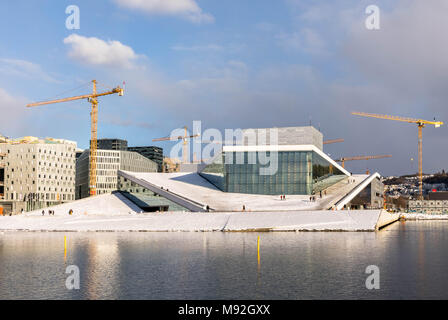 Oslo, Norvège, Mars 2018 : l'Opéra d'Oslo en hiver, entouré par des grues. Le Fjord d'Oslo, à l'avant. Banque D'Images