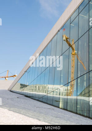 Oslo, Norvège, le 16 mars 2018 : Réflexions d'une grue dans les fenêtres de l'Oslo Opera House à Bjorvika. Banque D'Images