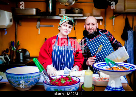 Les ruines de New York, 16 février 2018. Femme dans un foulard et mâle homme chef dans un tablier sur un stand de la nourriture chaude, cabine ou une cuisine qui pose pour l'appareil photo Banque D'Images