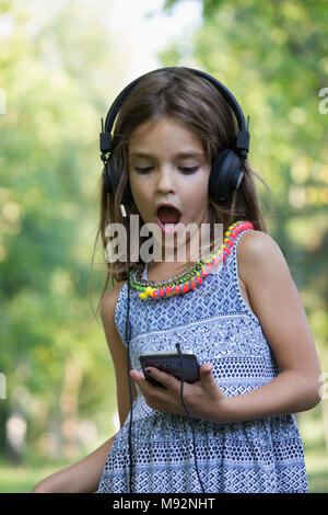 Petite fille douce avec casque Banque D'Images