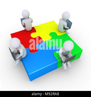 Quatre personnes avec des ordinateurs portables connectés assis sur des pièces de puzzle Banque D'Images
