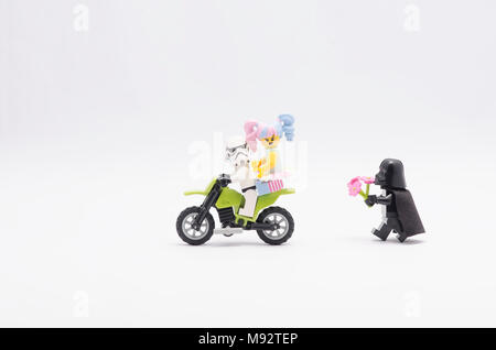 Dark Vador lego avec fleur chasing storm trooper avec n-pop girl riding dirt bike, isolé sur blanc baclground. Banque D'Images