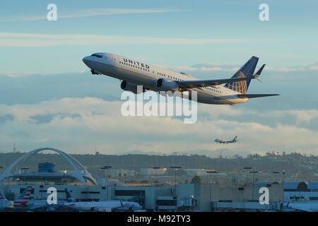 United Airlines Boeing 737-900 Avion de ligne au décollage de l'Aéroport International de Los Angeles, LAX. Le thème des capacités et un plan d'atterrissage derrière. Banque D'Images