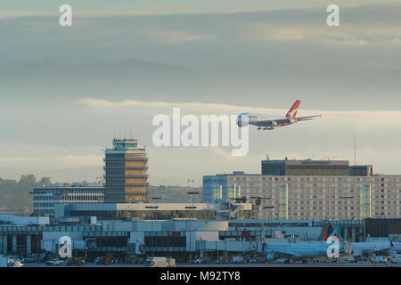 Airbus A380 de Qantas Passenger Jet en approche finale de l'Aéroport International de Los Angeles, LAX. Couvert de nuages montagnes San Gabriel derrière. Banque D'Images