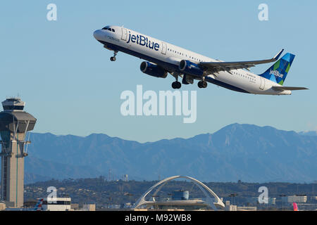 JetBlue Airways Airbus A321 Jet passagers décollant de l'Aéroport International de Los Angeles, LAX. La tour de contrôle et les montagnes San Gabriel derrière. Banque D'Images