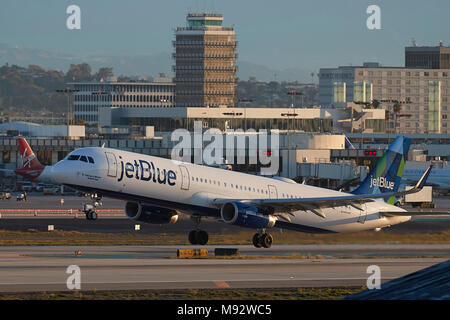 JetBlue Airways Airbus A321 Avion de ligne au décollage de l'Aéroport International de Los Angeles, LAX, tôt le matin, l'ancienne tour de contrôle derrière. Banque D'Images