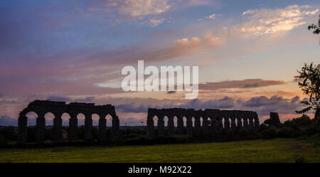 Voir l'ancien aqueduc romain de ruines dans la campagne de Rome au coucher du soleil Banque D'Images