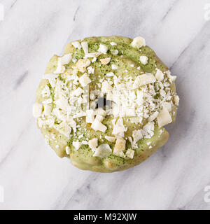 Matcha et chocolat blanc donut avec glaçure colorée et saupoudre sur surface en marbre Banque D'Images