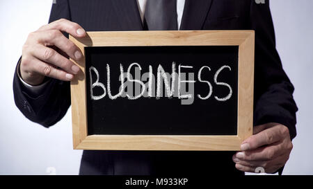 Les écrits sur tableau noir, man in suit holding sign, leadership, buts Banque D'Images