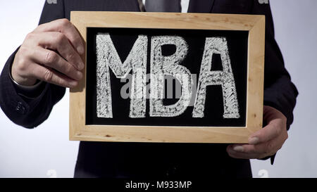 MBA écrit sur tableau noir, de personne d'affaires holding sign, business education Banque D'Images