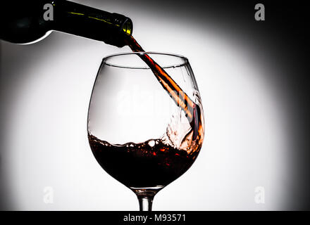 Le vin rouge est versé à partir de la bouteille en verre de vin Banque D'Images