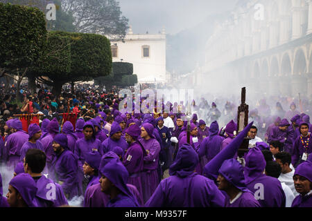 Les hommes en robe pourpre d'épaisseur de la fumée d'encens à la procession San Bartolomé de Becerra, Antigua, Guatemala Banque D'Images