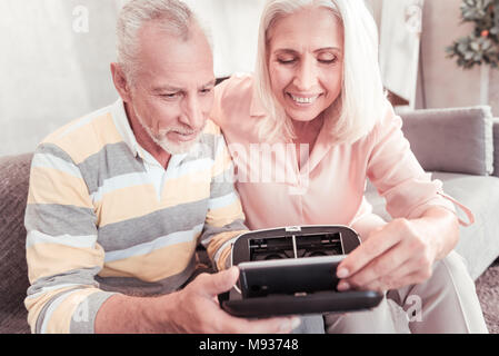 Smart couple occupé et d'essayer d'utiliser le gadget. Banque D'Images