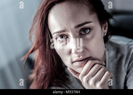 Femme rousse stressant à son menton à droite. Banque D'Images