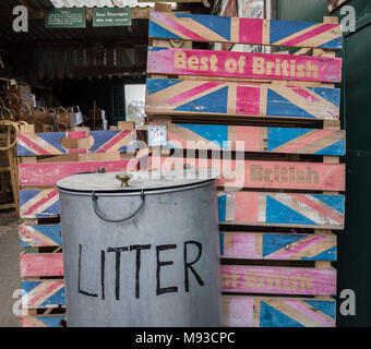 Une pile de "Best of British" caisses de légumes en bois debout à côté d'une corbeille métallique. Glastonbury, Somerset. Banque D'Images