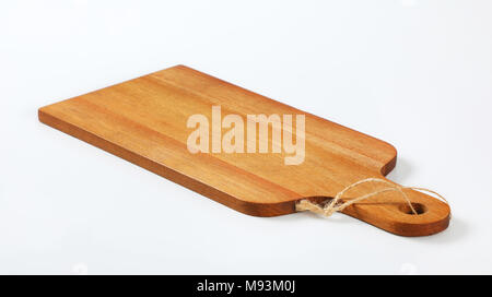 Planche à découper en bois avec poignée et string sur fond blanc Banque D'Images