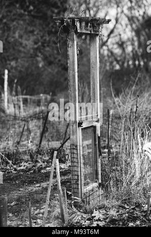 Une porte qui ne mène nulle part marque l'entrée d'une parcelle de jardin communautaire à Lexington, Massachusetts, en attente pour le printemps à arriver. Banque D'Images