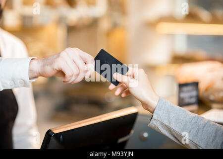 Payez par carte de crédit dans le magasin avec les produits de boulangerie Banque D'Images