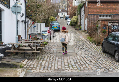 Quelqu'un à monter les rois Hill, une rue pavée historique sur une colline escarpée dans le marché de la ville historique sur Arundel, West Sussex, Angleterre, Royaume-Uni. Banque D'Images