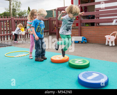 L'école maternelle des enfants jouent dans une aire de jeux dans le Warwickshire, Royaume-Uni Banque D'Images