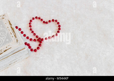 Coeur rouge collier de perles faites de sur fond blanc Banque D'Images