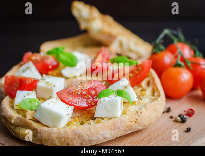 Friselle démarreur italien. Frisella classique tomate, fromage mozzarella et basilic et d'origan et d'huile d'olive. Pain séché sur freselle appelé boa en bois Banque D'Images