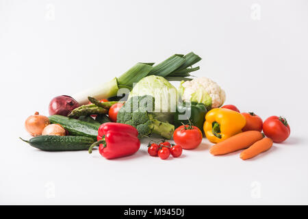 Divers légumes portant sur fond blanc Banque D'Images