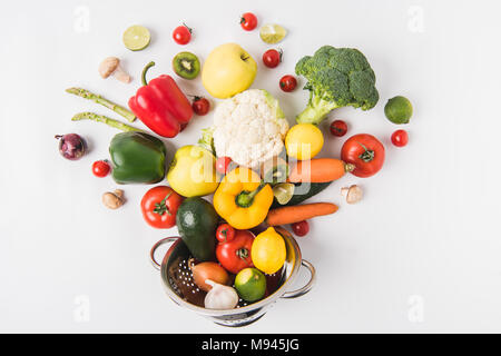 Mise à plat composition de légumes colorés et les fruits dans une passoire isolé sur fond blanc Banque D'Images