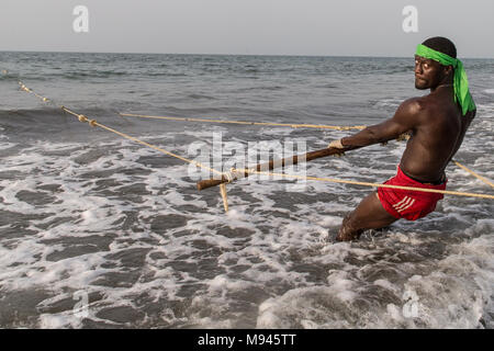 Les pêcheurs dans le village côtier de Kotu, Gambie, tirer dans leur filet de pêche dans l'espoir d'attraper le barracuda pour les touristes. Banque D'Images