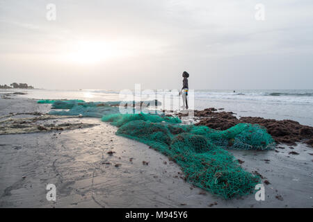 Les pêcheurs dans le village côtier de Kotu, Gambie, tirer dans leur filet de pêche dans l'espoir d'attraper le barracuda pour les touristes. Banque D'Images