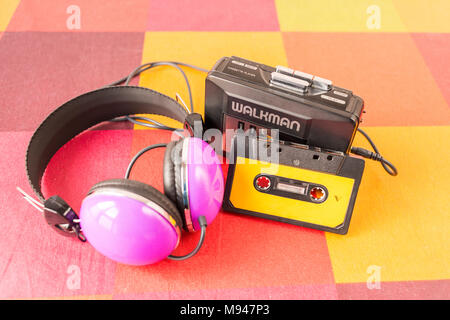 Walkman cassette, et casque sur une nappe à carreaux colorés. Banque D'Images