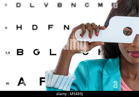 Jeune dame africaine de prendre un examen de la vue à une clinique de l'opticien avec l'arrière-plan sur les illustrations Banque D'Images