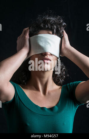 Portrait d'une femme aux cheveux noirs, les yeux bandés Banque D'Images