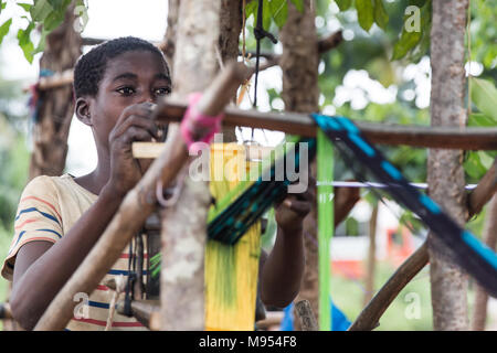 Lnor, 12 ans, travaille dans une petite usine de tissage dans Gbomi Kondeyaokro, centre de la Côte d'Ivoire. Il s'agit d'un Akan, célèbres pour leur tissu Kente (connu comme nwentom Akan) dans laquelle un type de soie et coton tissus faits de bandes de toile tissée. Banque D'Images