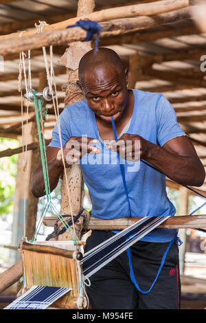 Un travailleur dans une usine de tissu de Korhogo Korhogo, nord de la Côte d'Ivoire. Korhogo est chiffon de tissu fait par le peuple sénoufo à la main Dessins Peinture sur main, main matière coton. Banque D'Images