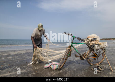 Momodou, un pêcheur local, tire dans ses prises de rouget dont il espère vendre aux collectivités locales de restaurants dans la ville touristique de Kotu, la Gambie. Banque D'Images