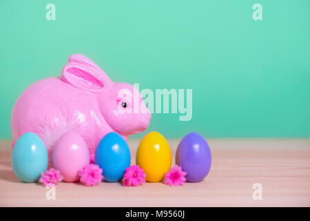 Lapin rose, couleur multi rangs peint des oeufs de Pâques et de fleurs sur fond vert, carte de souhaits fête Banque D'Images