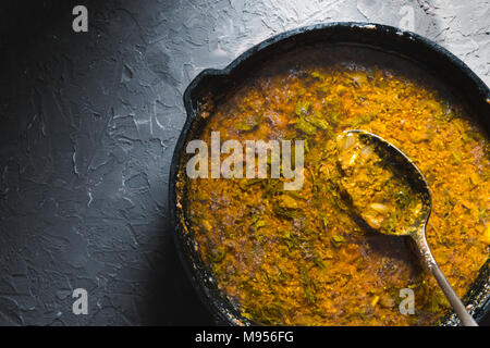 Préparation de la pâte de curry dans une poêle en fonte. La cuisine indienne l'horizontale Banque D'Images