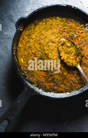 Préparation de la pâte de curry dans une poêle en fonte libre. Verticale de la cuisine indienne Banque D'Images