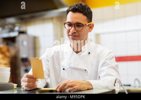 Chef cuisinier au kebab avec commande ou papier Remarque Banque D'Images