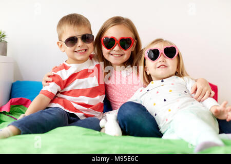 Heureux les petits enfants dans les lunettes à la maison Banque D'Images