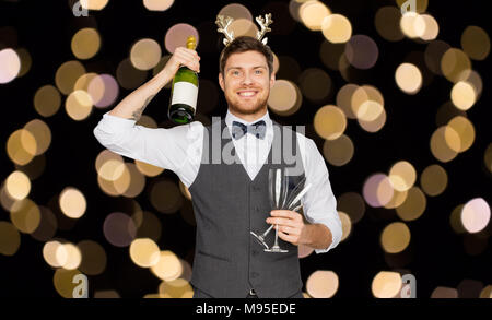 Homme avec bouteille de champagne at Christmas party Banque D'Images