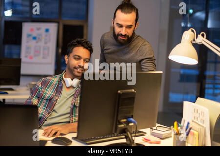 Équipe de création avec l'ordinateur travailler tard au bureau Banque D'Images