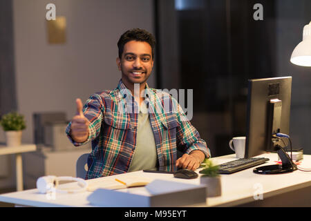 Creative man showing Thumbs up at office de nuit Banque D'Images