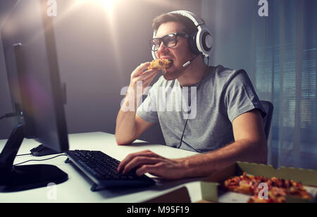 En jouant l'homme casque jeu vidéo sur ordinateur à la maison Banque D'Images