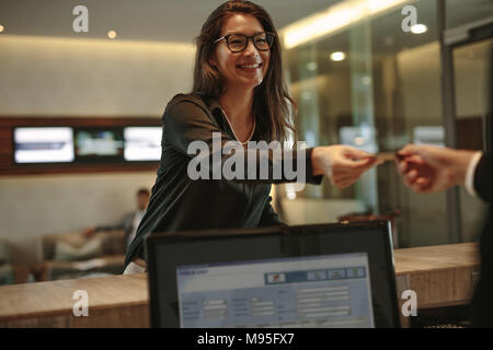 Asian businesswoman recevant carte clé pour chambre d'hôtel à la réception. Invité prenne femme prix carte-clé à l'arrivée 24. Banque D'Images