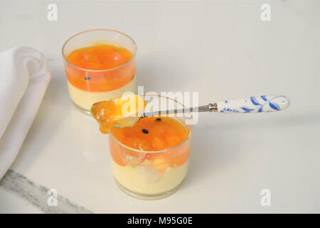 Mangue panna cotta dessert avec cuillère sur du marbre blanc Banque D'Images