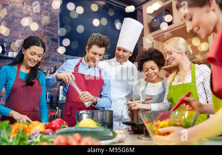 Heureux les amis et cuisine chef cuisinier dans la cuisine Banque D'Images